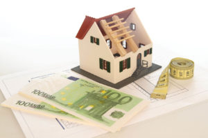 Afbeelding van een modelhuis en bankbiljetten die premies voorstellen.